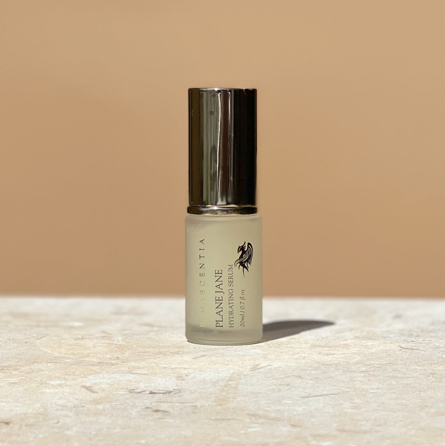 10ml plane jane hydrating serum in a bottle with gold lid on limestone base